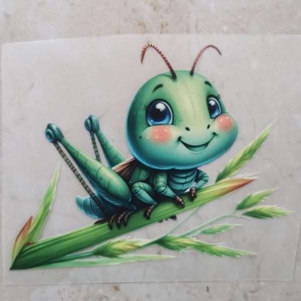 Bügelbild süße Heuschrecke auf Schilf